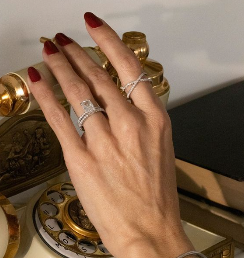 A woman wearing a valuable designer wedding band and other jewelry picks up the phone.