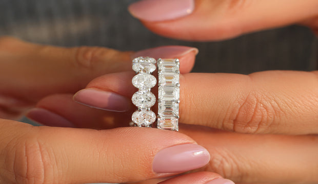 Woman wearing oval and emerald cut wedding bands.