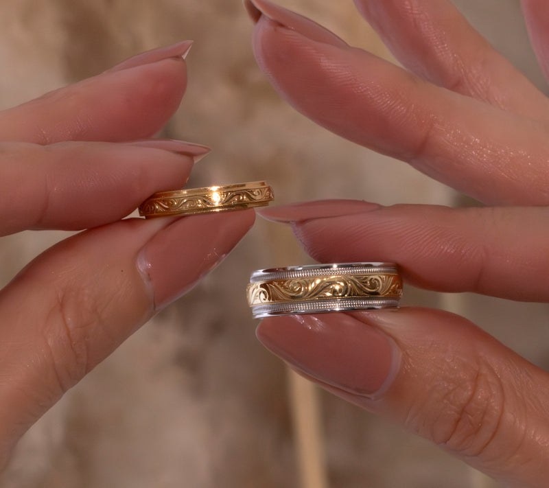 A woman holds women's and men's wedding rings at different widths.