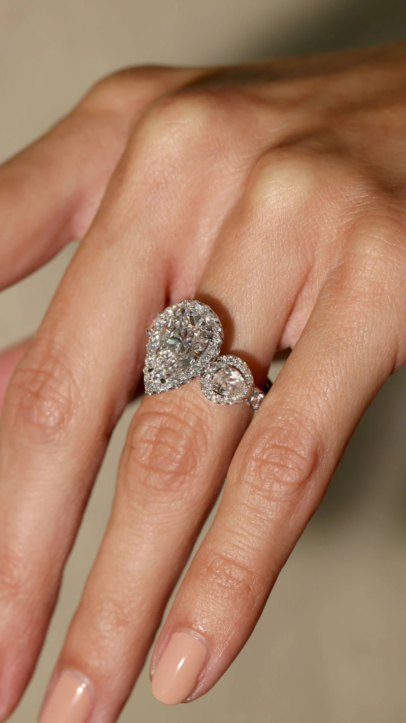 Pear shaped diamond engagement ring on fiancee hand