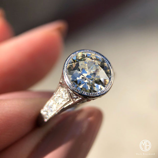 A woman holds a sparkly Antique Cut Diamond Ring. Professional jewelers explain how to clean your diamond ring to protect its brilliance.