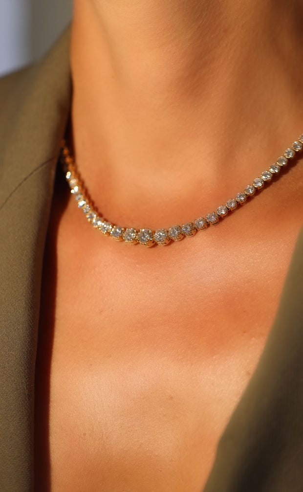 A woman wears a Diamond Tennis Necklace.