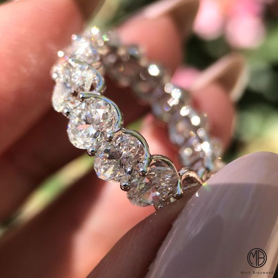 A woman holds an Oval Eternity Band in White Gold.