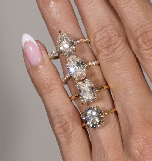 A woman wears many Engagement Rings with the Most Classic Diamond Shapes.