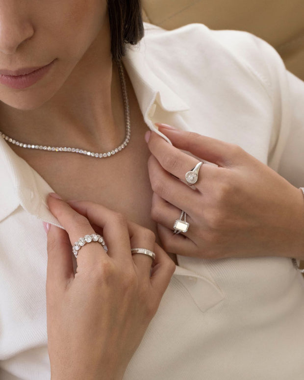 A woman wearing a Tennis Necklace wonders why some Tennis Necklaces flip.