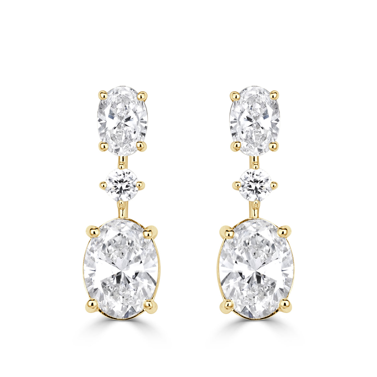 A pair of earrings with oval cut diamonds, round cut diamonds and a larger oval cut diamond at the bottom in yellow gold. 