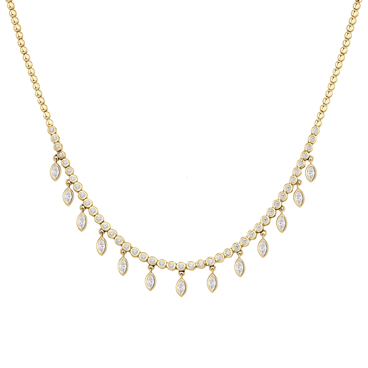 Round brilliant cut diamond and marquise diamond drop necklace set in yellow gold. 