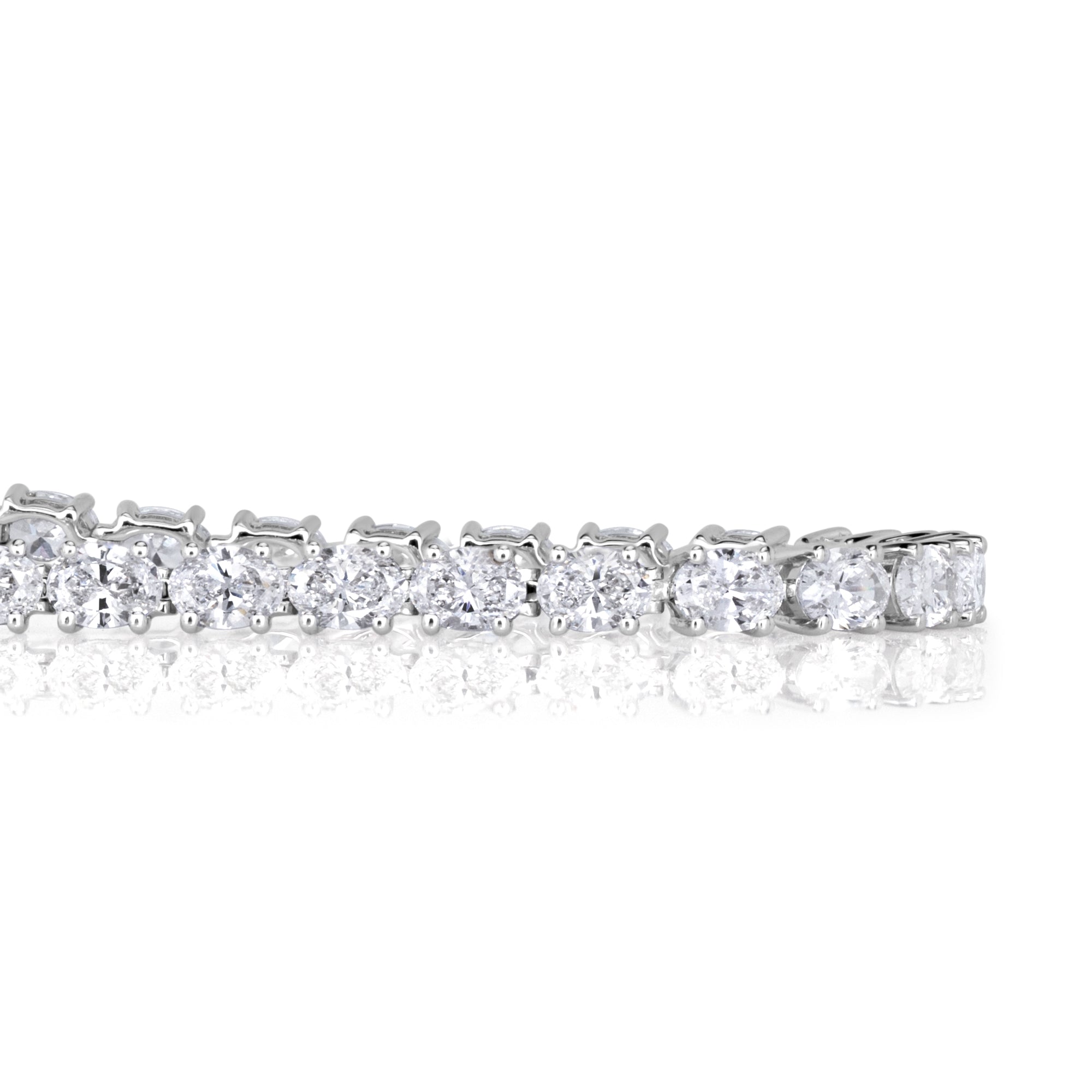 Detailed shot of oval cut diamond tennis bracelet in 18k white gold set with 4 prongs. 