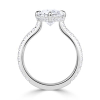 Platinum engagement ring with an elongated old mine cut diamond set with 4 prongs in a compass style, pave diamond band and hidden halo of diamonds under the center stone. 