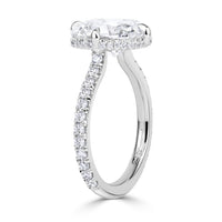 Platinum engagement ring with an elongated old mine cut diamond set with 4 prongs in a compass style, pave diamond band and hidden halo of diamonds under the center stone. 