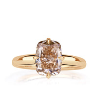 Elongated cushion cut fancy brown-orange set with four prongs compass style and pave diamond hidden halo. 