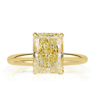 Elongated cushion cut canary yellow diamond with a hidden halo and yellow gold band. 