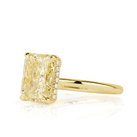 Elongated cushion cut canary yellow diamond with a hidden halo and yellow gold band. 