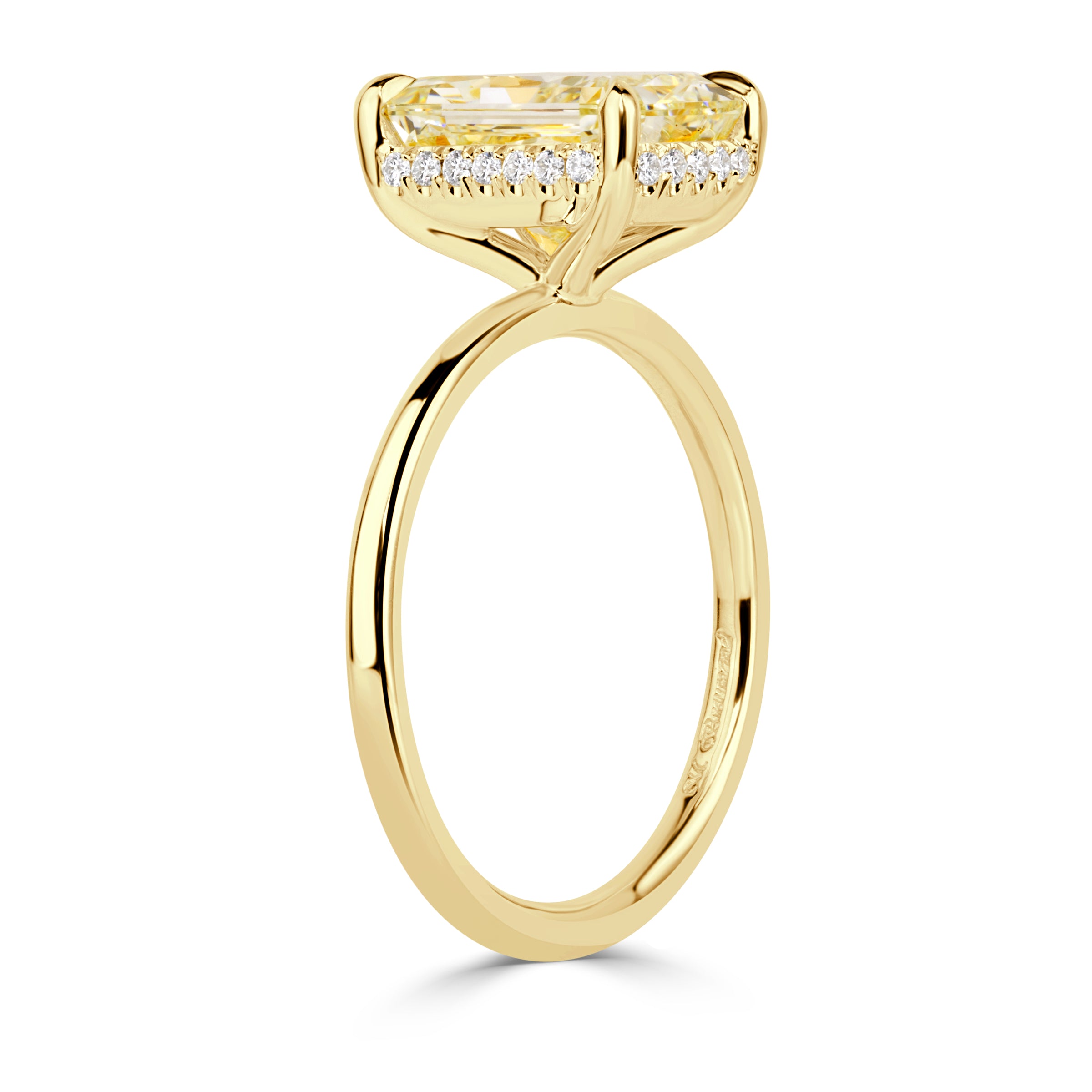 Elongated cushion cut canary yellow diamond with a hidden halo and yellow gold band. 