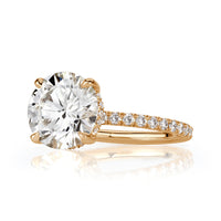 Side view of Round cut lab grown diamond with pave diamond band and hidden halo of diamonds in 18k yellow gold. 